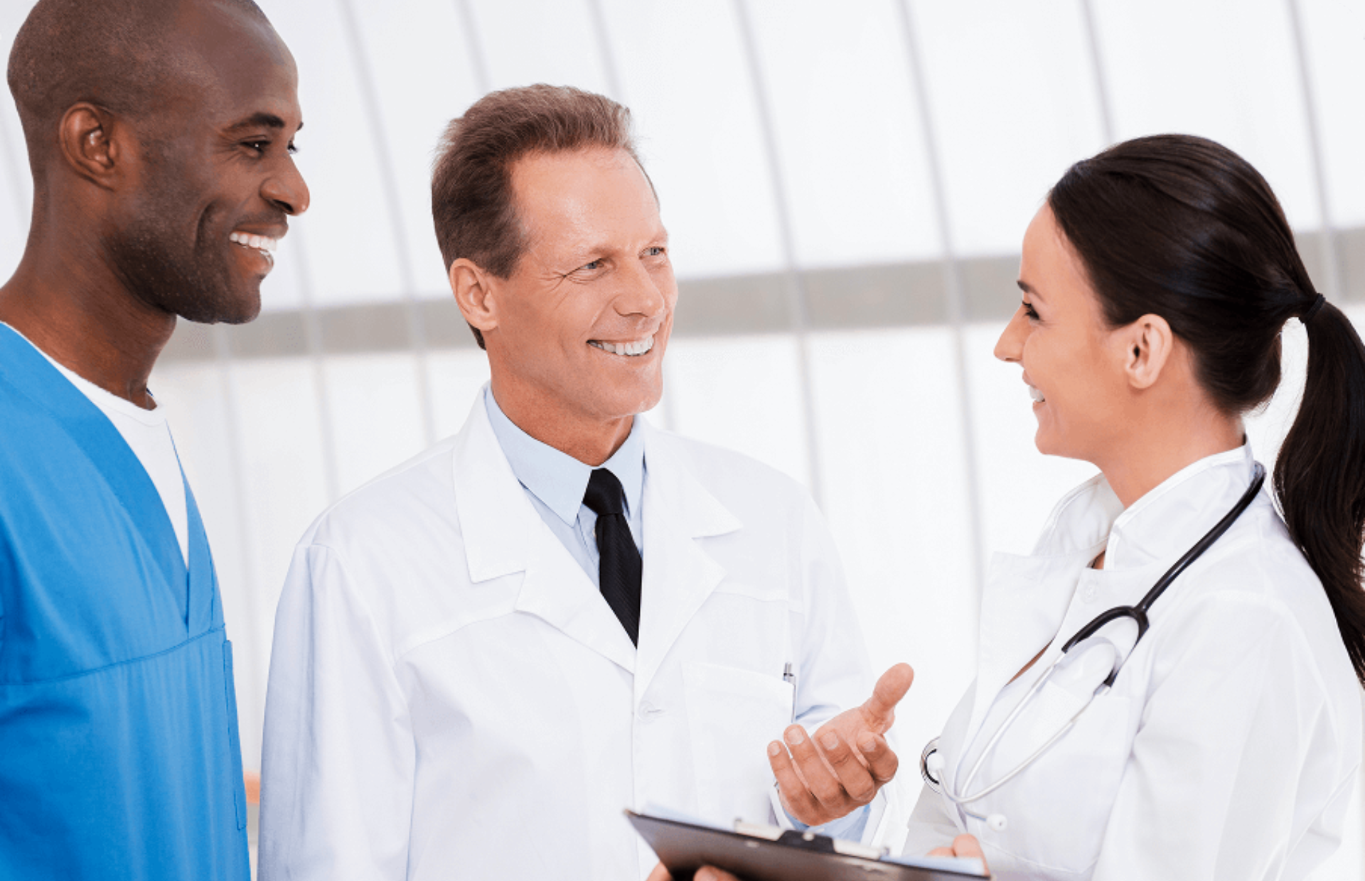 Three medical professionals discussing in a bright hospital.